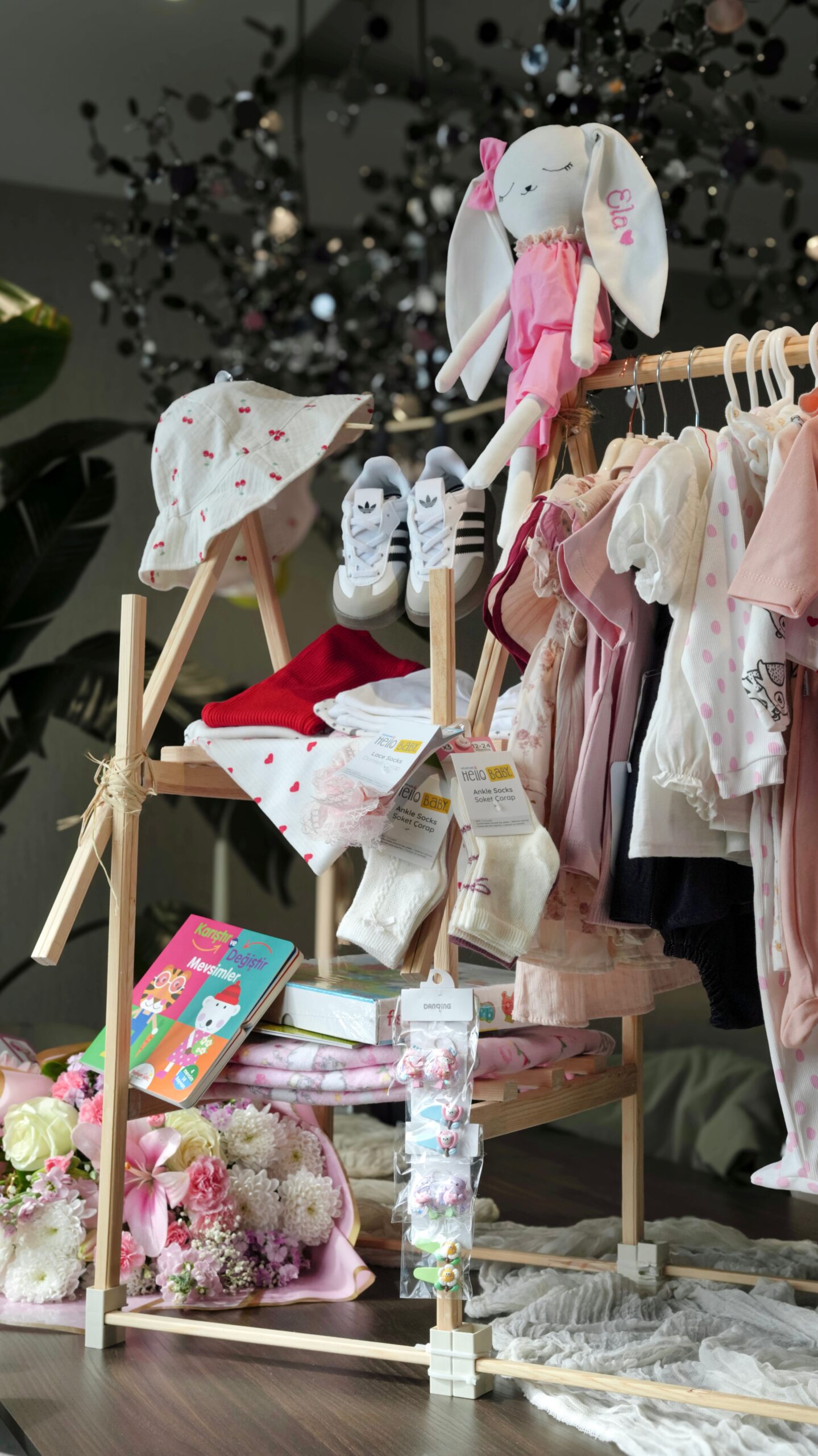 Baby clothing display with adorable outfits, shoes, socks, toys, and accessories in a boutique
